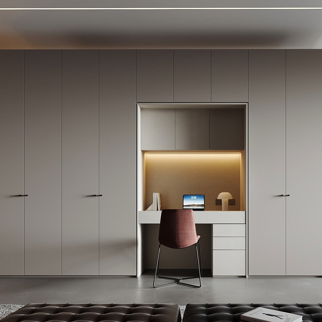 Woodex built-in wardrobe wall with an integrated desk nook, accent chair and concealed storage